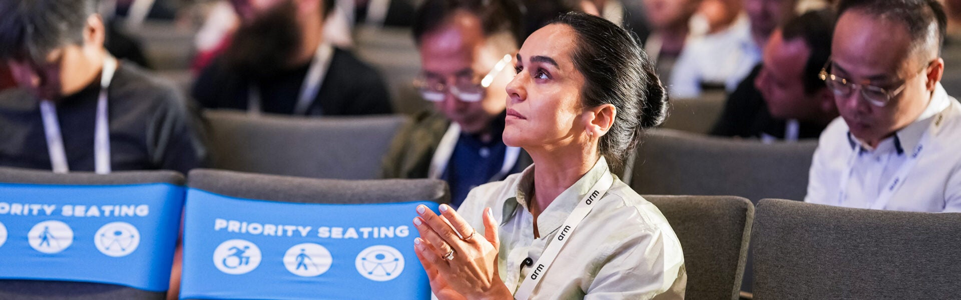 Audience member applauding during a conference session.